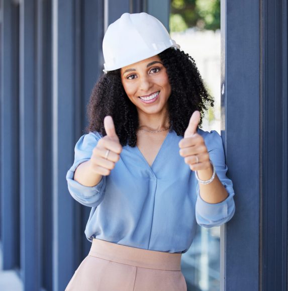 Black woman, portrait smile and thumbs up for construction, building or good job with hard hat for on site work safety. Happy African American female architect, engineer or builder showing thumbsup.